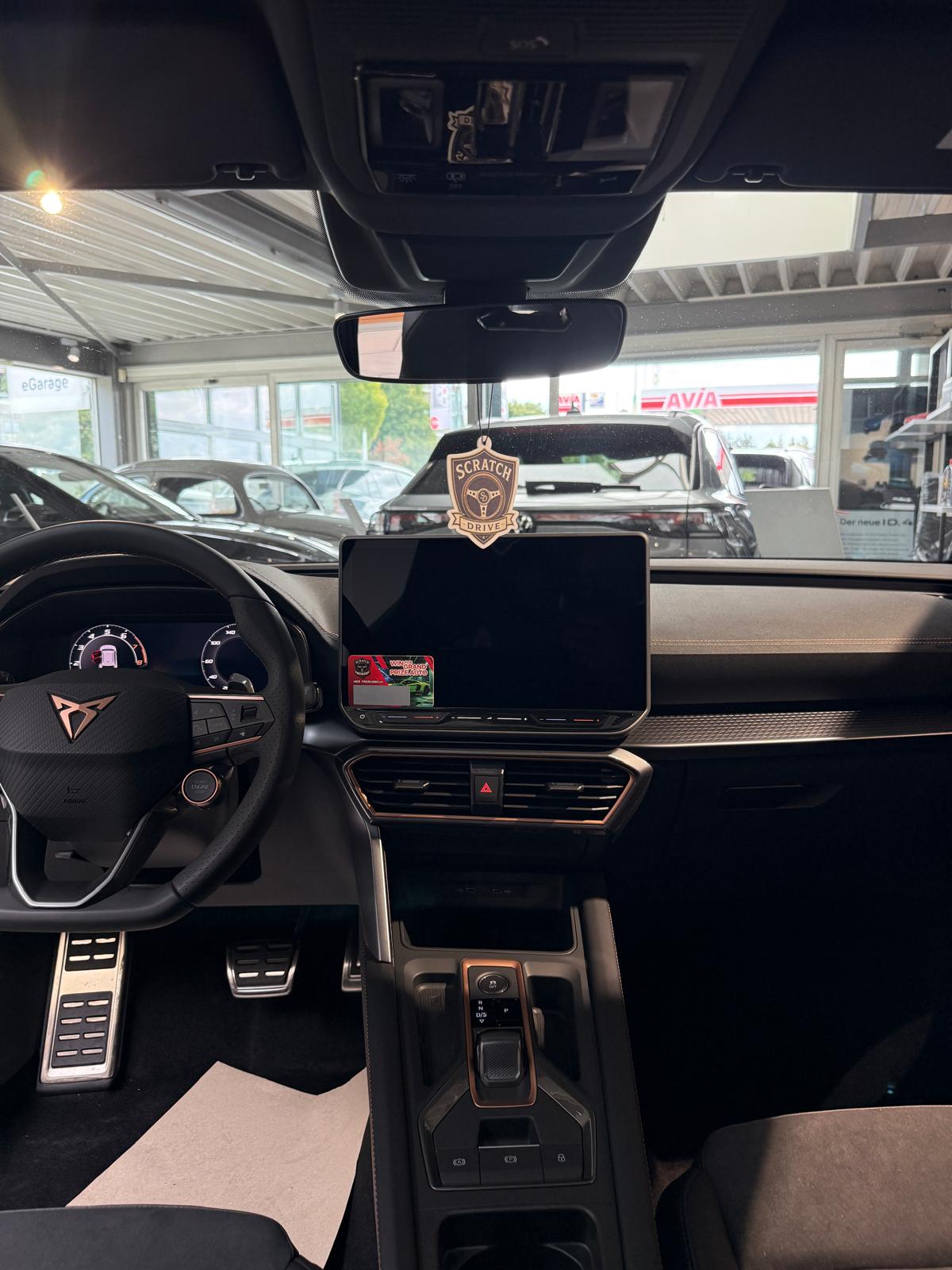 Innenansicht eines Autos mit Scratch & Drive Metall-Badge am Rückspiegel